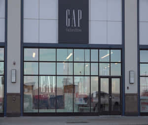 GAP Factory Store 正面，帶有關閉標誌和反射周圍環境的玻璃窗。