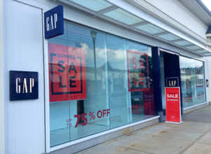 Gap 服裝店，玻璃櫥窗上以大型紅色字體顯示夏季減價75%折扣的標誌。