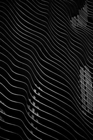 現代建築外牆上的波浪形建築線條，黑白配色。 — 美學 iPhone 壁紙