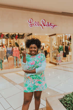 身穿花卉連衣裙的女性在 Lilly Pulitzer 商店前微笑。