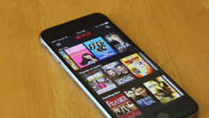 智能手機在木桌上顯示Netflix應用程式