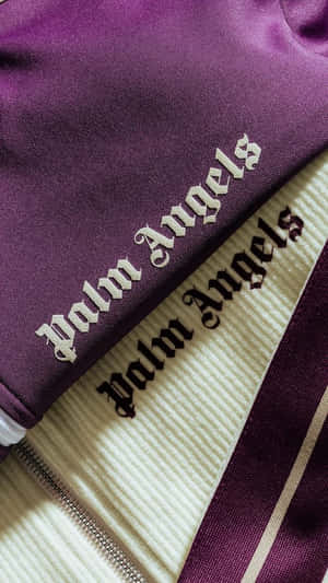紫色和奶油色Palm Angels外套，帶有刺繡標誌和拉鍊細節。