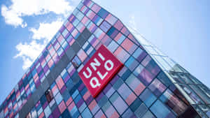 現代玻璃建築，彩色面板和UNIQLO標誌，藍天白雲下。