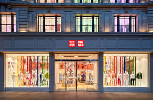 夜晚的 Uniqlo 商店正面，櫥窗內有彩色展示和人體模型。