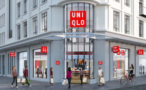 人們走過帶有紅色標誌和玻璃窗的 Uniqlo 服裝店。