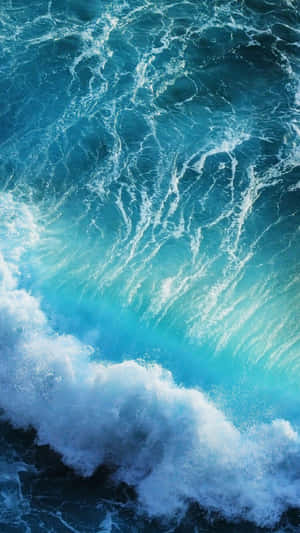 強勁的海浪拍打，呈現出藍綠色海水和白色泡沫。