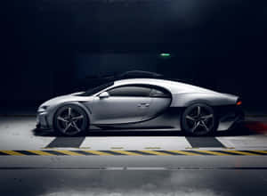 銀色Bugatti超跑在黑暗的工業車庫中，地面有黃色條紋。