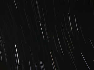 星軌在長時間曝光照片中劃過夜空。 — 黑色動態圖 壁紙