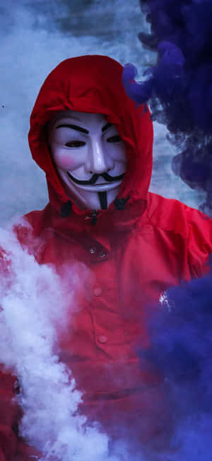 穿著紅色連帽衫和蓋伊·福克斯面具的人被旋轉的煙霧包圍。