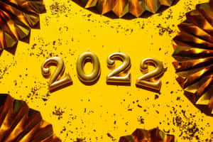 金色2022蠟燭被金屬扇和五彩紙屑包圍在黃色背景上 — 新年動畫 壁紙