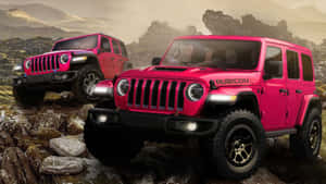 兩輛粉紅色Jeep Rubicon SUV在山區景觀中行駛在岩石上。