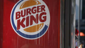 Burger King 標誌喺紅色玻璃店面，有城市倒影。