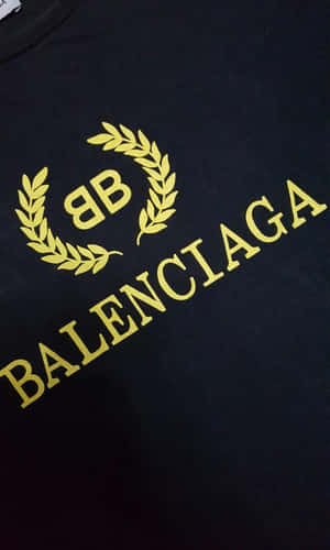 黑色T恤，帶有金色Balenciaga標誌和月桂花環設計。