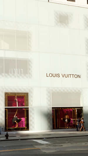 城市街道上帶有粉紅色櫥窗展示和幾何陰影的Louis Vuitton商店。