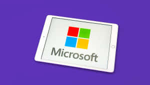 白色平板電腦在紫色背景上顯示Microsoft標誌