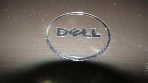 金屬表面上有灰塵和刮痕的 Dell 筆記型電腦標誌。