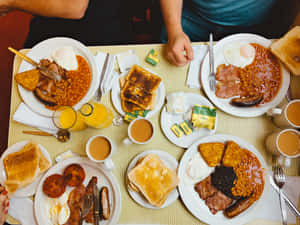 全英式早餐，有雞蛋、豆子、多士和飲品，放在黃色格仔枱布上。 — 早餐動圖 壁紙
