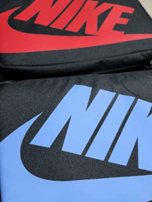 兩個Nike品牌袋，帶有紅色和藍色標誌，位於黑色布料上。