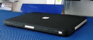 關閉的黑色手提電腦在藍色紋理墊子上，工作空間