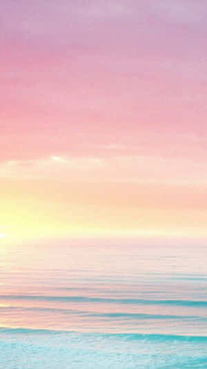 平靜海浪上的柔和粉彩日出