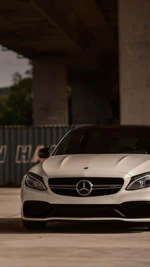 白色Mercedes-AMG停放在混凝土天橋下，帶有戲劇性的燈光效果。