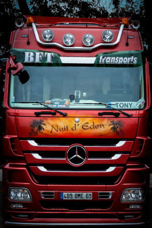 紅色Mercedes-Benz卡車，帶有「Nuit d'Eden」棕櫚樹設計和「BFT transports」標誌。