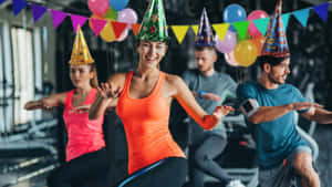 戴著派對帽的人在裝飾過的健身房裡運動。 — 生日蛋糕 壁紙
