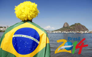 粉絲穿著巴西國旗斗篷和黃色假髮，面向甜麵包山，帶有「Brasil 2014」標誌。