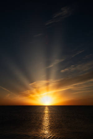 夕陽下的海洋，金色光芒與平靜水面