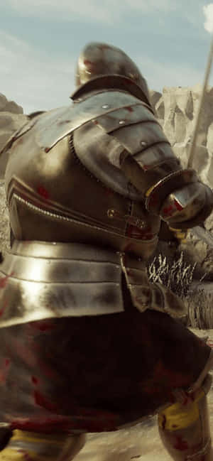 一名血跡斑斑的騎士身穿盔甲，站在日落時分的岩石沙漠中。 — iPhone 16 Plus 壁紙