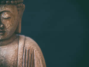 深青色背景上，閉著眼睛的木製佛像特寫。 — 禪 壁紙