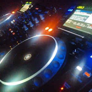 在黑暗的俱樂部中發出藍色和橙色光芒的 DJ 控制器。