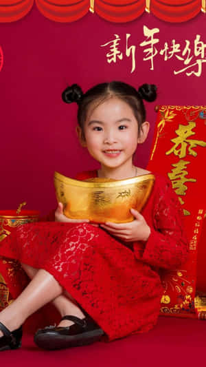 穿著紅色裙子的小女孩為農曆新年慶祝拿著金條。