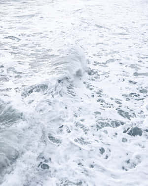 泡沫海浪翻滾，白色浪花與灰藍色海水。