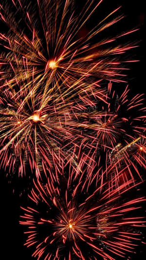 爆炸性的紅色和金色煙火照亮夜空。 — 9:16 壁紙