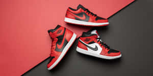 三對紅、黑、白色的 Air Jordan 1 運動鞋，背景為紅黑色。