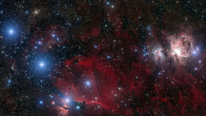 一個宇宙場景，有發光的紅色和藍色星雲以及無數星星。