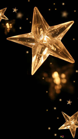 金色星光在黑暗中閃爍，背景柔和發光散景。 — 省電 壁紙