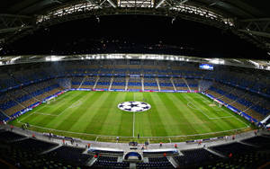 夜間照明的一個大型空足球場，場地上有UEFA Champions League標誌。