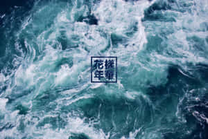 翻騰的碧綠海浪，帶有白色泡沫和日本文字疊加。