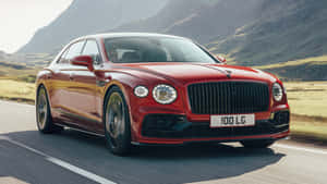 紅色賓利 Flying Spur 在日落時分於山路疾馳。