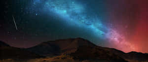 在色彩繽紛的星空下，山脈剪影伴隨一顆流星。