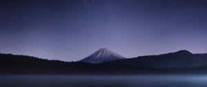 富士山在繁星夜空下，下方有霧氣瀰漫的湖泊 — 超寬螢幕 壁紙