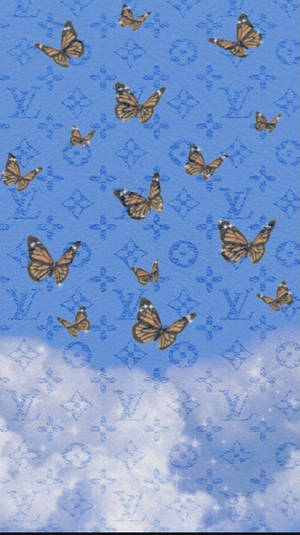 蝴蝶在藍天白雲和 Louis Vuitton 字母圖案上飛翔。