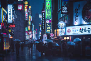 撐傘的行人在雨夜中走過霓虹燈照亮的城市街道。