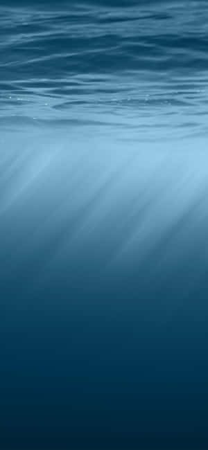 陽光穿過海面照射到深藍色海水中。