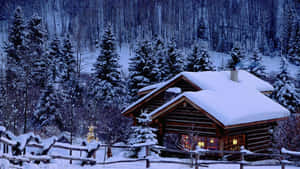 雪林中的舒適小木屋，黃昏時溫暖的燈光閃爍。 — 聖誕節桌面 壁紙