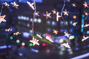 星燈在模糊的城市夜景中柔和地發光。 — 聖誕燈飾 壁紙