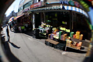 魚眼視角下的熱鬧街市，充滿色彩繽紛的商品和店舖門面。