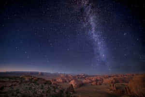夜晚紅色岩石沙漠峽谷上的銀河系 — 星星 壁紙